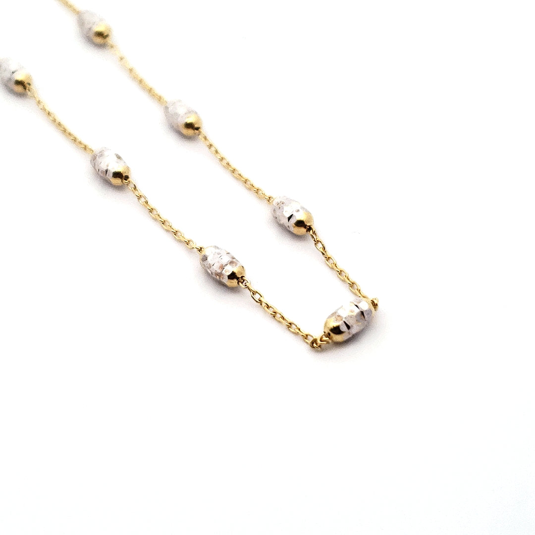 A 10K 2 Tone Gold Anklet with adjustable gold chain and silver-colored beads.