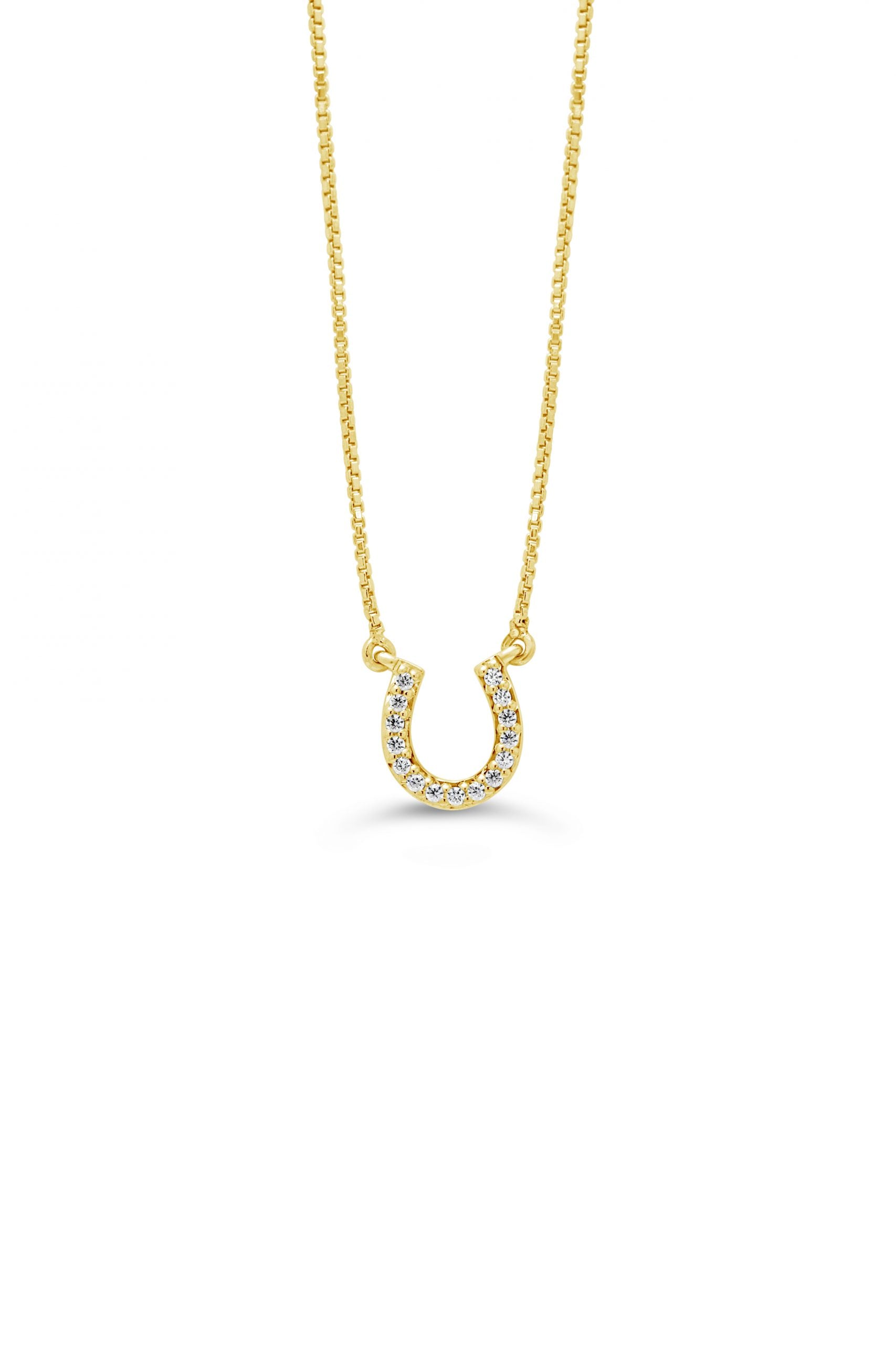 A 10K yellow gold horseshoe pendant with diamond accents on a white background.