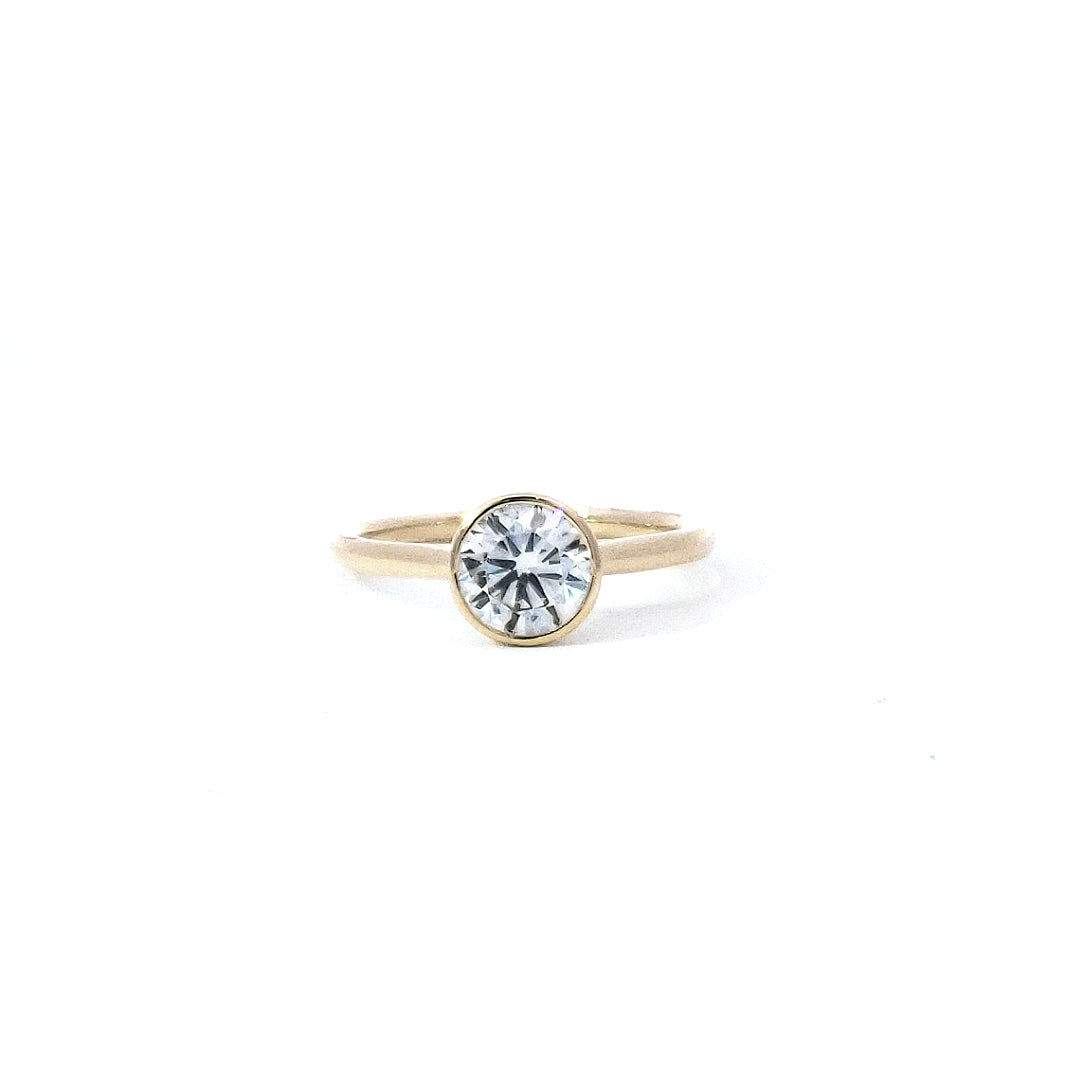 A 14K gold bezel-setting lab grown diamond ring with a single diamond visible on the ring's top surface.