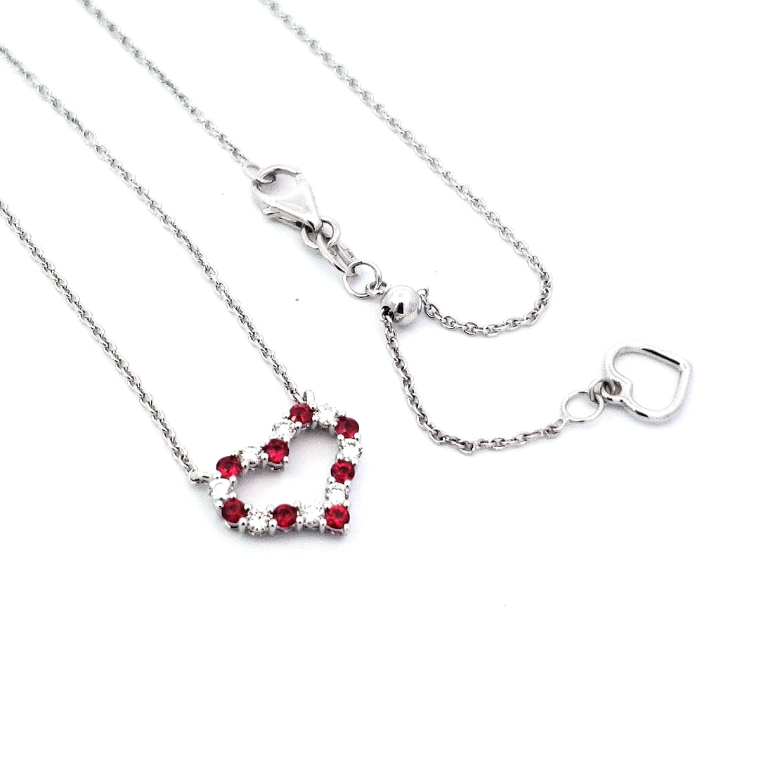 A 14K yellow gold pendant featuring a red ruby and a white diamond, attached to a silver cable chain.