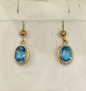 Aretes de topacio azul en oro blanco de 14 quilates