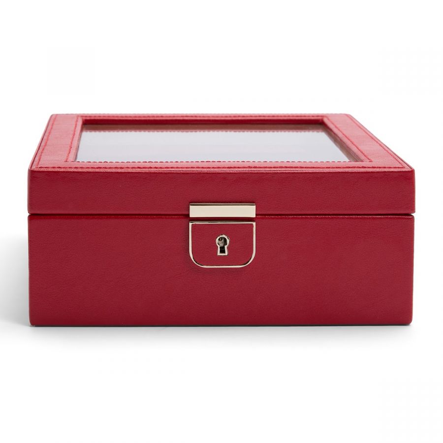 A red leather watch box with a secure lock and key, featuring a clear glass top and suspended watch cushions.