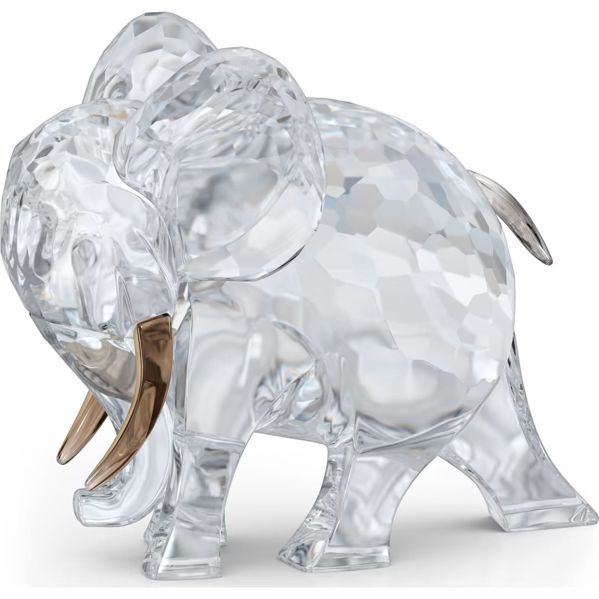 A clear crystal elephant figurine with a special coating on the tusks and tail, on a white background.