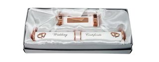 Rose gold wedding rings and certificate set in a box on a white background