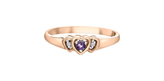 Rose gold ring with heart-shaped design and purple gemstone on a white background