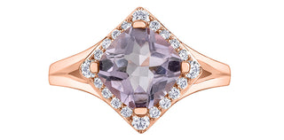 Rose gold ring with a purple gemstone and diamond accents on a white background