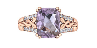 Rose gold ring with a purple gemstone and diamond accents on a white background