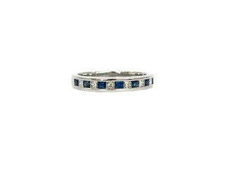 Silver ring with embedded blue and clear gemstones on a white background