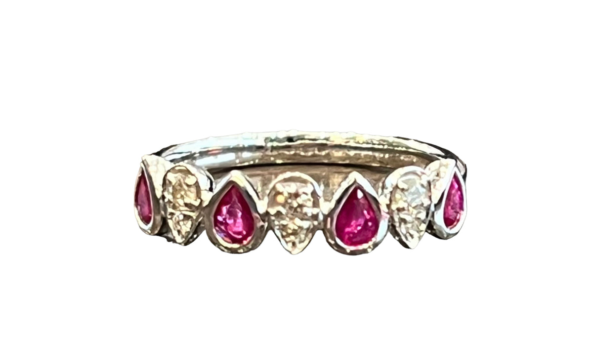 Ring with pink teardrop-shaped gemstones and clear stones on a white background
