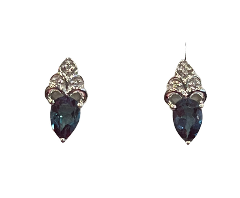 Pair of earrings with blue teardrop stones and silver embellishments on a white background