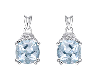 Pair of silver pendants with clear gemstones on a white background