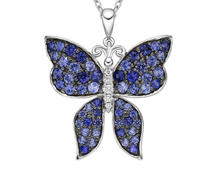 Butterfly-shaped pendant with blue gemstones on a white background