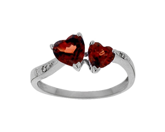 Silver ring with two heart-shaped red gemstones on a white background