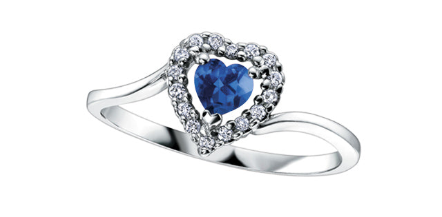 Silver ring with a blue heart-shaped gemstone on a white background