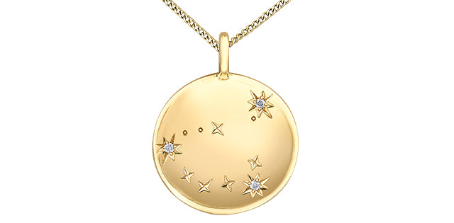 Gold necklace with a round pendant featuring star designs on a white background
