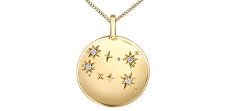 Gold necklace with a round pendant featuring star designs and small diamonds on a white background