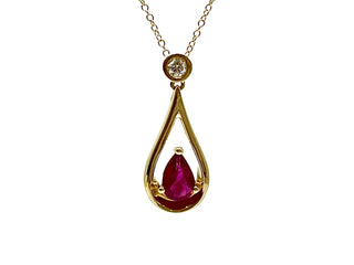 Gold pendant with a teardrop-shaped red gemstone on a white background