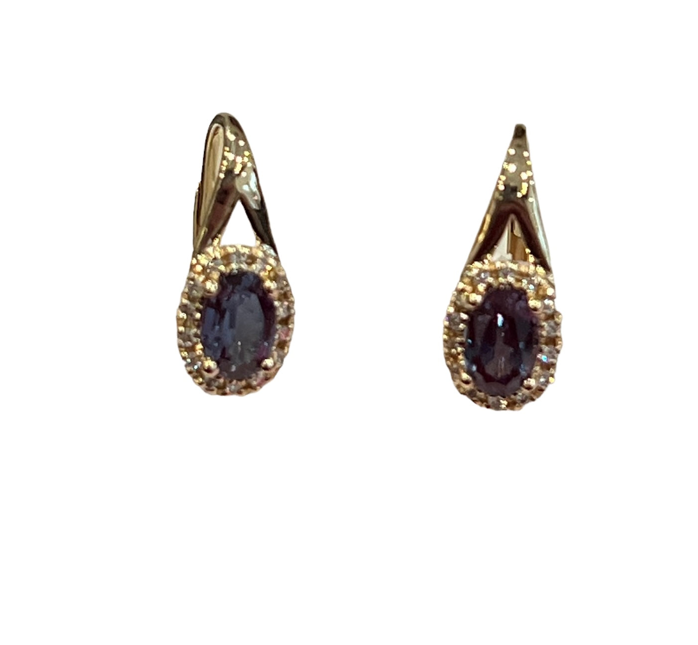 Pair of gold earrings with dark gemstones on a white background