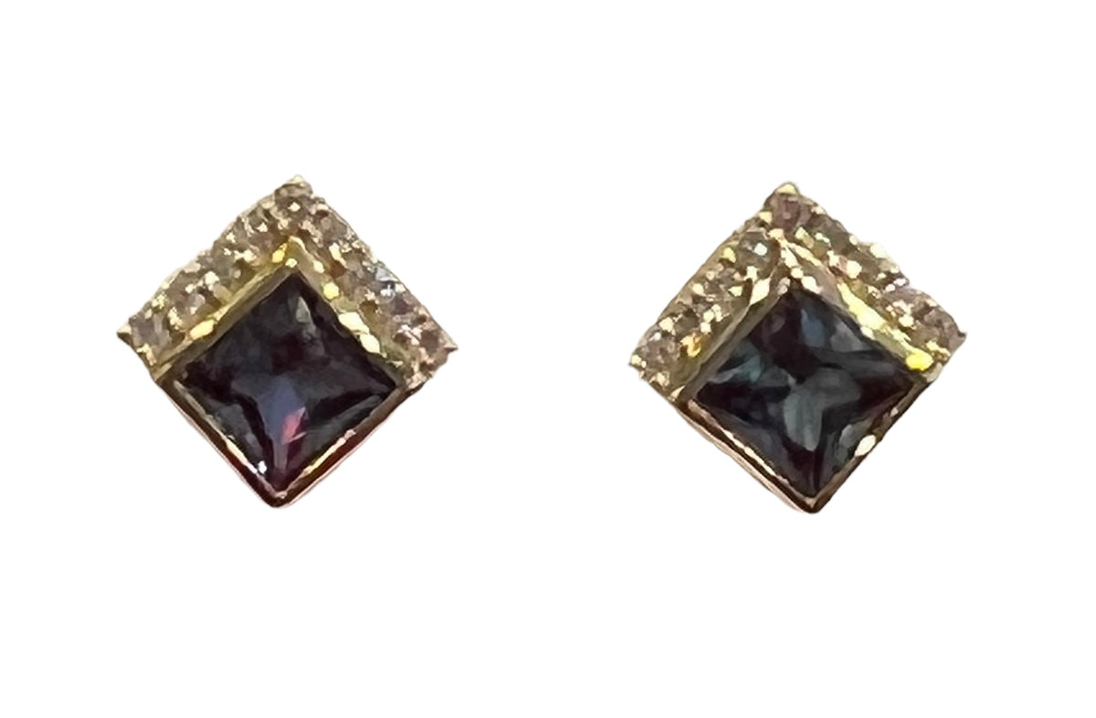 Pair of square-shaped earrings with black gemstones and gold accents on a white background