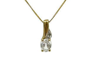 Gold pendant with a diamond on a white background