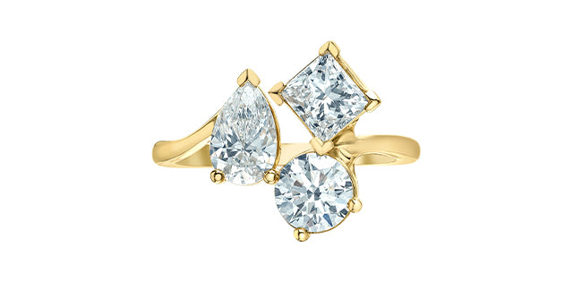 Gold ring with three clear gemstones on a white background