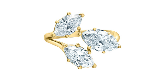 Gold ring with three pear-shaped diamonds on a white background