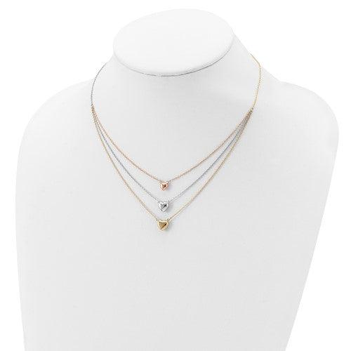 Three gold necklaces with heart pendants on a mannequin bust against a white background