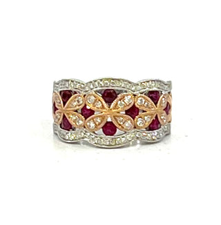 Ring with red gemstones and gold accents on a white background
