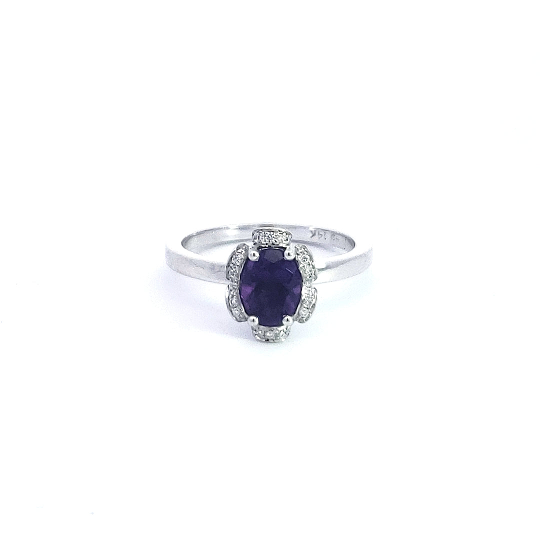 Silver ring with a purple gemstone on a white background