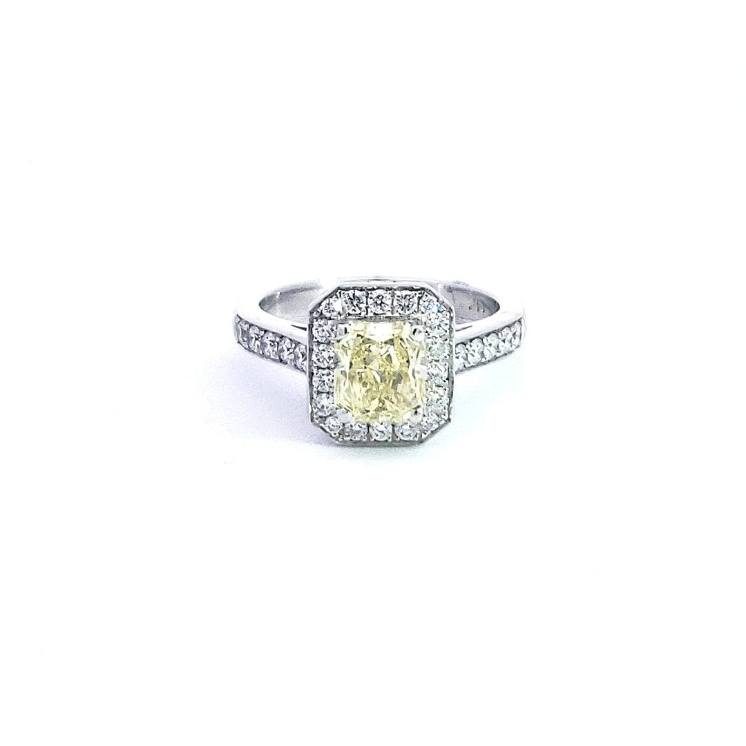 Diamond ring with a yellow center stone on a white background
