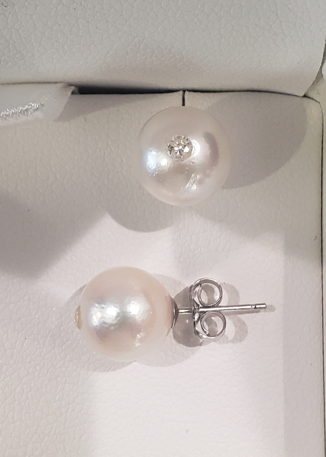 Pearl earrings with silver posts on a white background