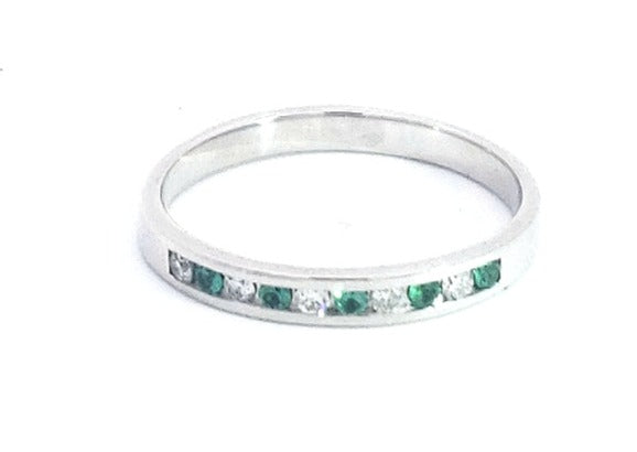 Silver ring with green and clear gemstones on a white background