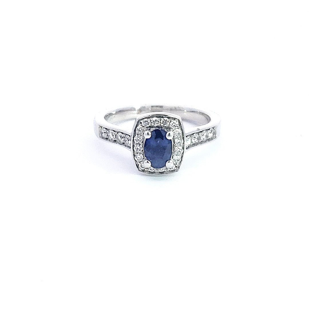 Silver ring with a blue gemstone and diamond accents on a white background