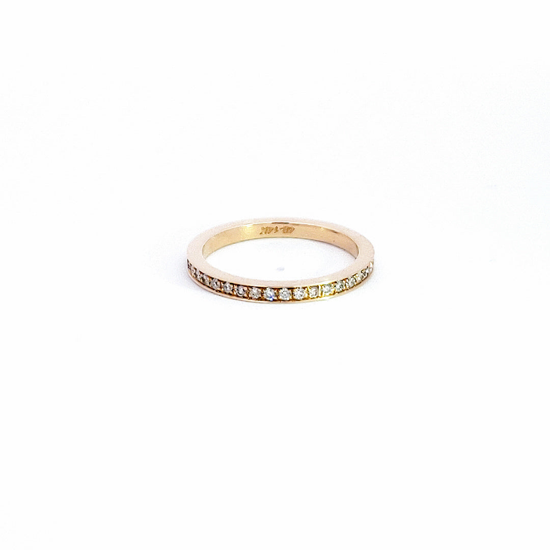 Gold ring with small diamonds on a white background