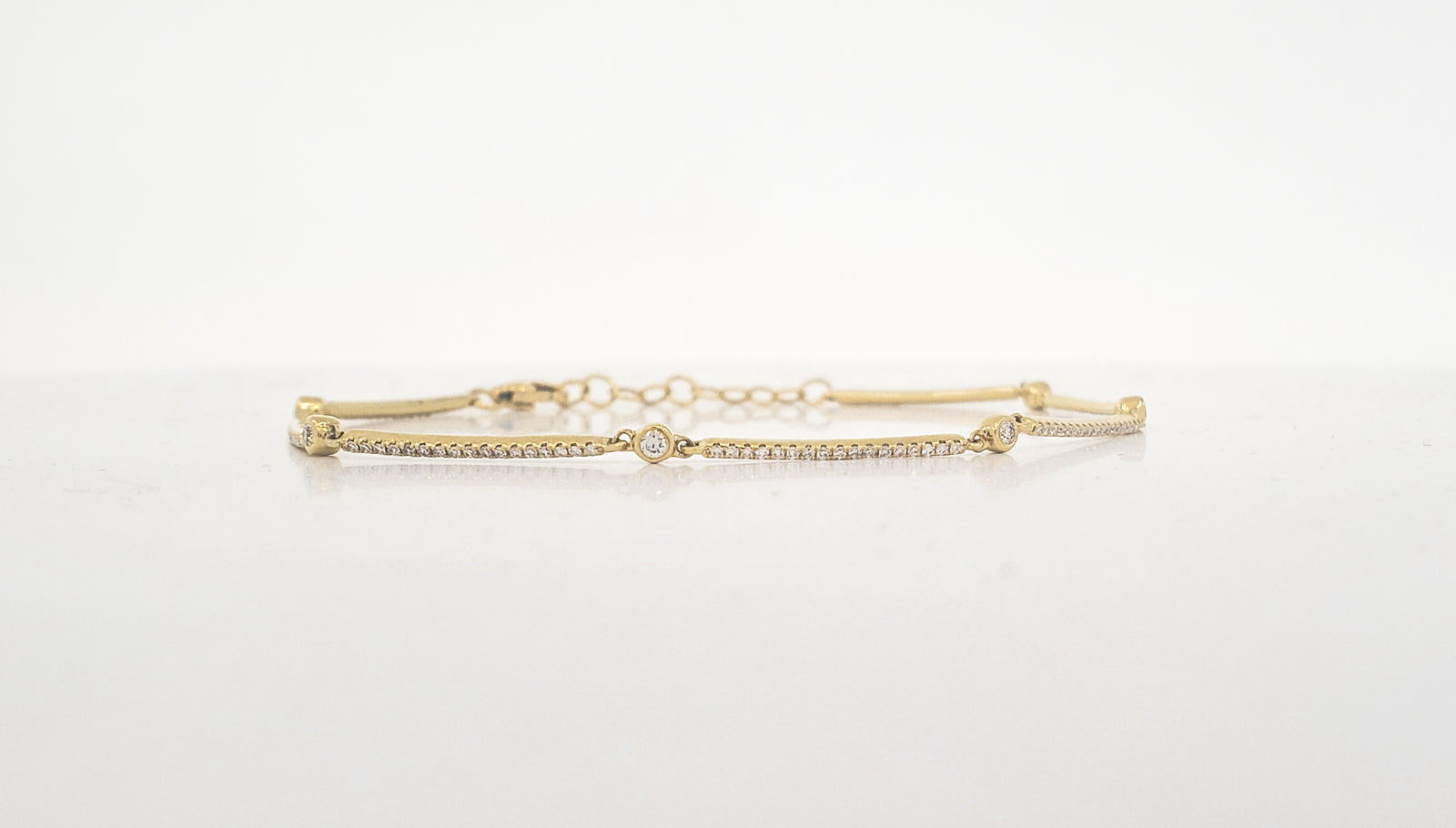 Gold bracelet with a diamond on a white background