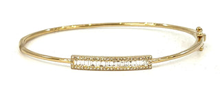 Gold bangle with a bar design on a white background