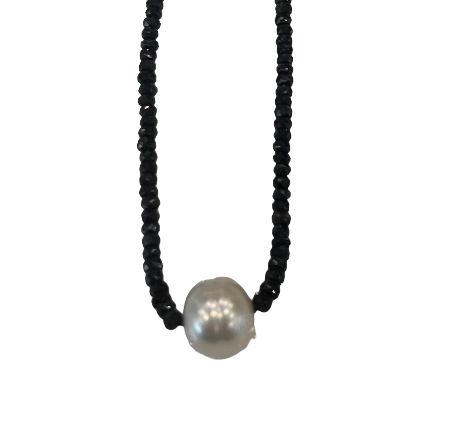 Necklace with black beads and a single white pearl on a white background