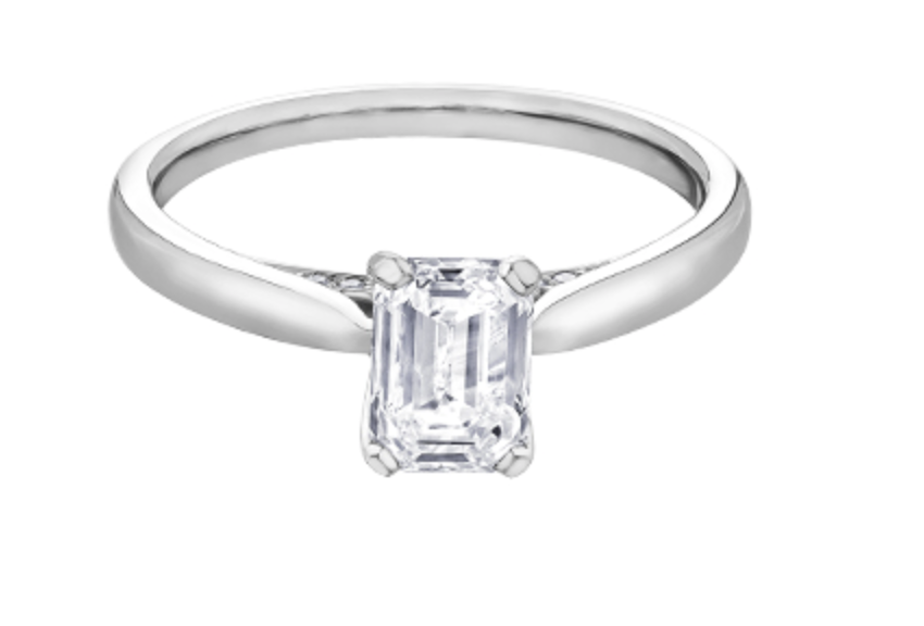 Diamond ring with emerald-cut gemstone on a white background