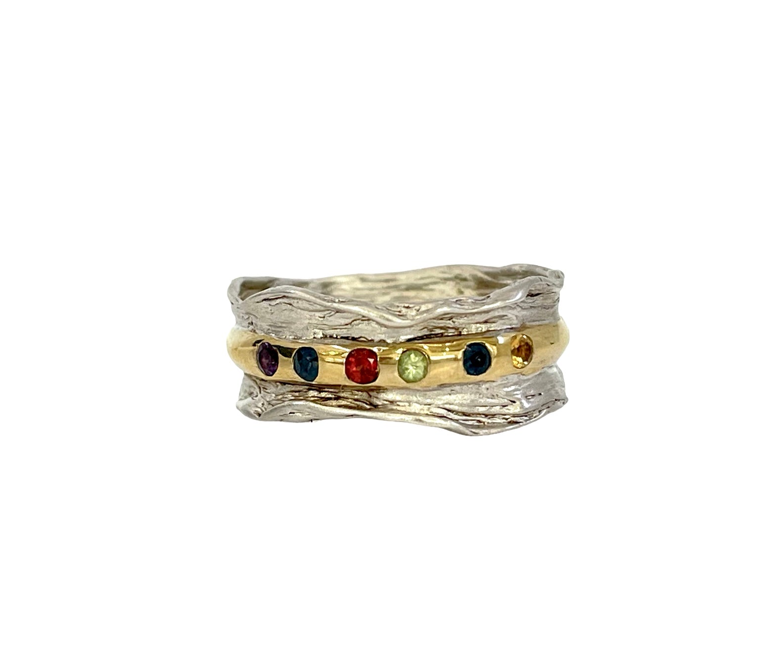 Ring with gold band and multicolored gemstones on a white background