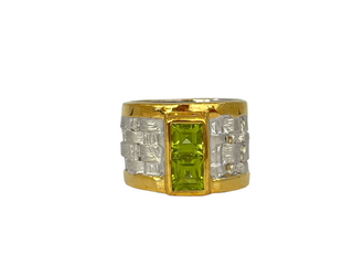 Gold and silver ring with a green gemstone on a white background