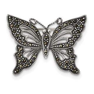 Butterfly-shaped brooch with intricate design on a white background