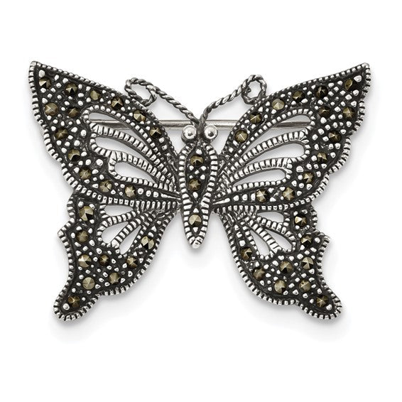Butterfly-shaped brooch with intricate design on a white background