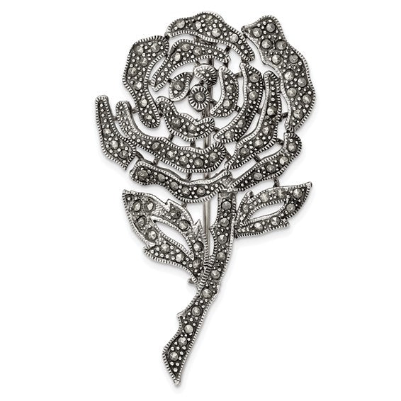 Decorative rose brooch with intricate design on a white background