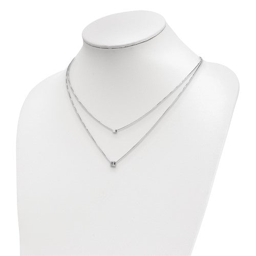Silver necklace on a mannequin bust against a white background