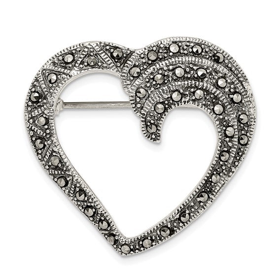 Heart-shaped brooch with decorative elements on a white background