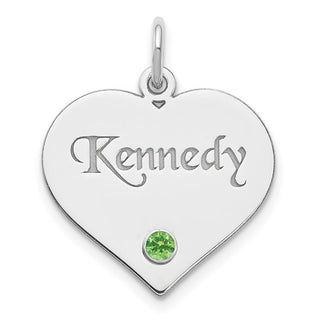 Heart-shaped silver pendant with 'Kennedy' engraving and green gemstone on a white background