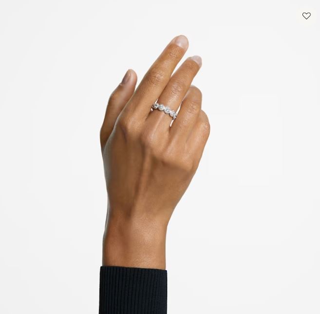 Hand wearing a diamond ring on a plain background