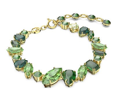 Gold bracelet with green gemstones on a white background