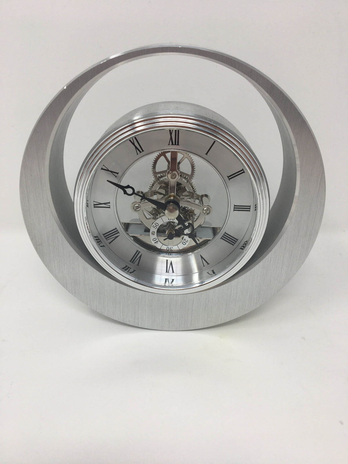 Reloj redondo plateado con movimiento de latón.